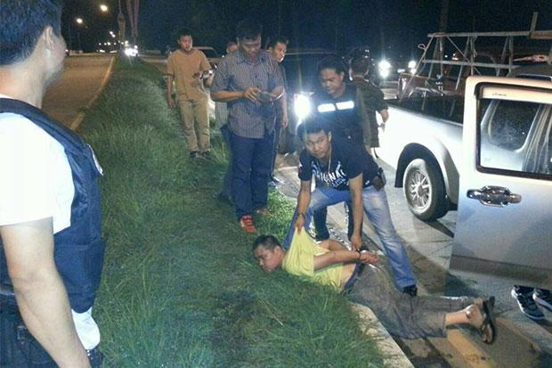 Charoen Chumchan, 41, is handcuffed after plainclothes police find over one million methamphetamine pills in five fertiliser sacks inside his pickup truck stopped for a search in Mae Chan district of Chiang.