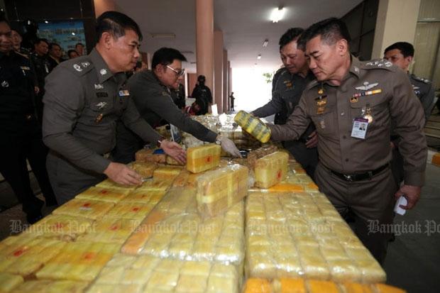 National police chief Chakthip Chaijinda, right, inspects narcotics shown at a news conference at the Royal Thai Police Office in Bangkok on Monday. (Photo by Chanat Katanyu)